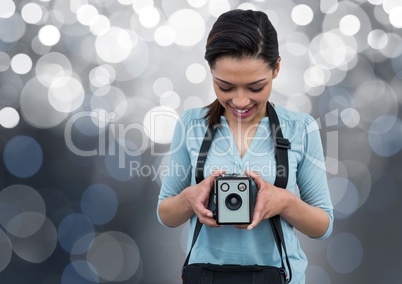 happy photographer with vintage camera. Silver bokeh behind