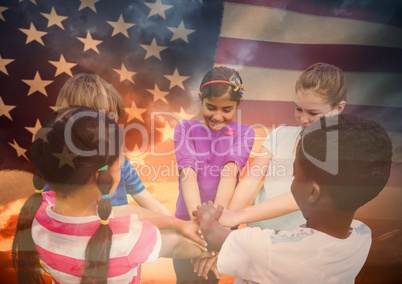 Children with hands together  against american flag