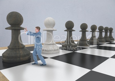 Business man pushing 3D chess piece against grey wall
