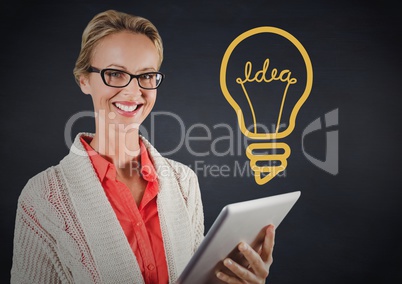 Business woman with tablet against navy wall with yellow idea graphic