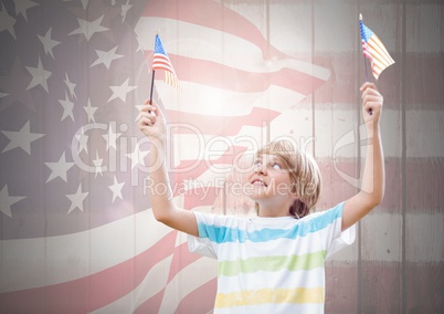 Happy boy holding two 3d american flags against a wooden background