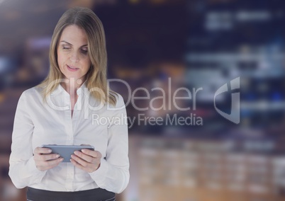 Businesswoman using a digital tablet against buildings in background