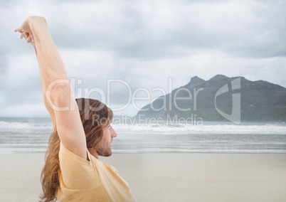 Man stretching against blurry beach