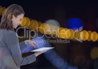 Smiling woman using a digital tablet with spotlights