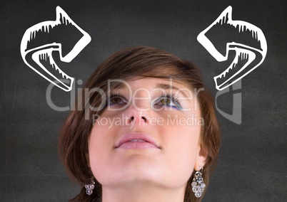 Woman looking up at white curved arrows against grey wall