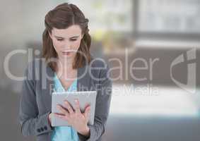 Pretty woman texting on a digital tablet at home