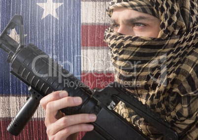 Soldier holding firearm against american flag
