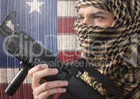 Soldier holding firearm against american flag