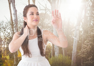 Woman in white summer dress against blurry trees with flare