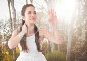 Woman in white summer dress against blurry trees with flare