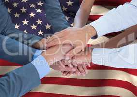 People putting their hands together on an american flag