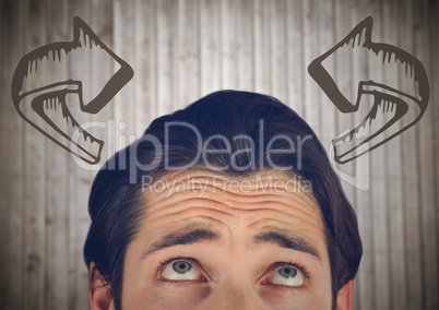 Top of man's head looking at curved 3D arrows against blurry wood panel