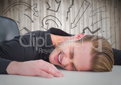Frustrated business man at desk against blurry wood panel and 3D arrow graphics