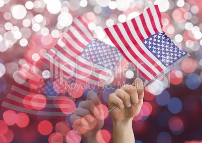 Hands holding american flags against shiny background