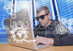 Hacker with sunglasses using a laptop in data center