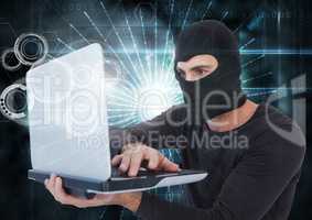 3d Hacker with hood using a laptop in front of digital background