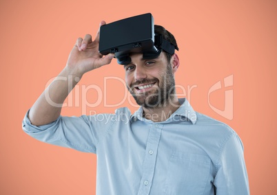 Man in virtual reality headset against peach background