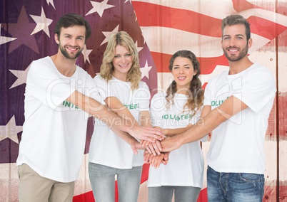 Smiling friends putting their hands together against american flag