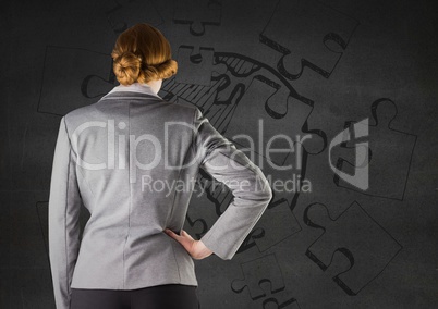 Back of business woman against grey wall and jigsaw doodle