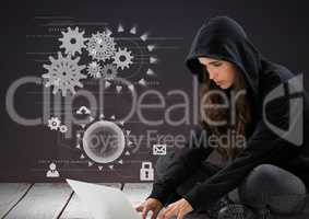 Woman hacker using a laptop in front of purple background with 3d digital icons