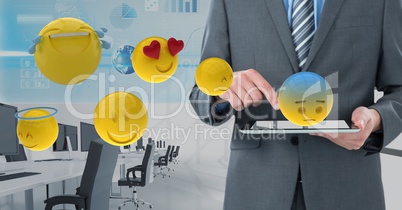 Midsection of businessman using digital tablet with 3d various emojis