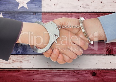 Handshake with handcuffs against wooden american flag background