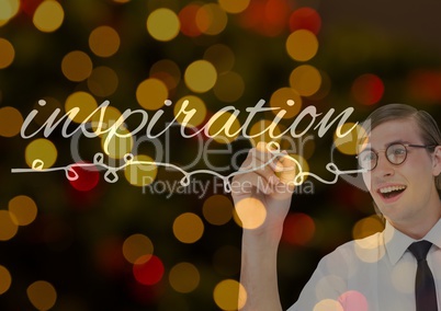 Young happy businessman writing INSPIRATION in the screen. Blurred lights background and overlap