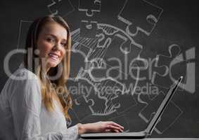 Woman at laptop against grey wall with 3D white jigsaw doodle