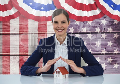 Business woman covering a house against american flag