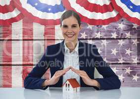 Business woman covering a house against american flag