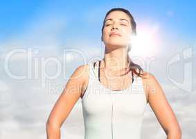 Woman soaking up sun against sunny sky with flare
