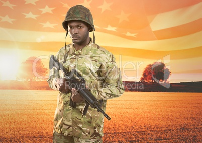 Soldier holding a weapon in front of field