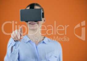 Woman in virtual reality headset against orange background