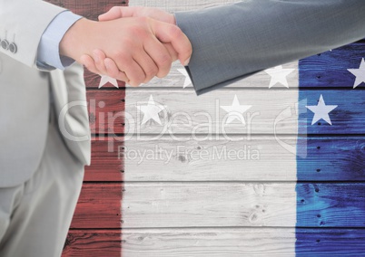 Two 3d men handshaking against a wooden background with american flag