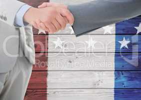 Two 3d men handshaking against a wooden background with american flag