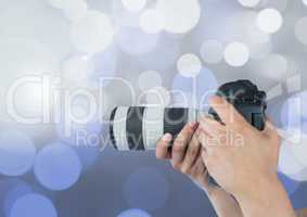 hands holding a camera against glowing background