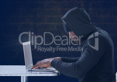 Side view of hacker using a laptop in front of blue background