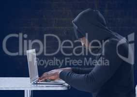 Side view of hacker using a laptop in front of blue background