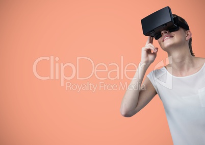 Woman in virtual reality headset against peach background