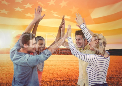 Friends high fiving against sunset landscape