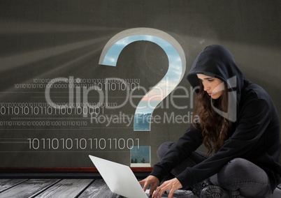 Woman hacker seated and working on a laptop with a grey background with a 3D question mark