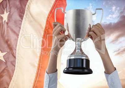 Part of a man holding a cup above his head against fluttering american flag