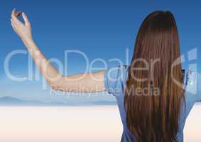 Back of woman with arms outstretched against blurry desert