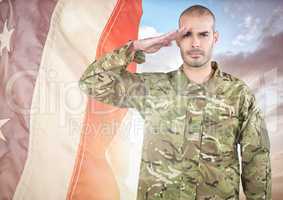 Soldier saluting against a fluttering american flag