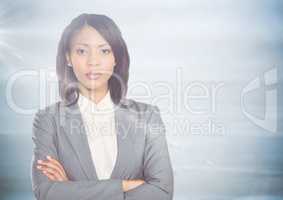 Business woman arms folded against blurry blue wood panel