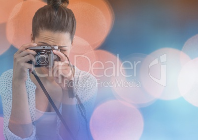 Pretty photographer taking picture in colored lights background