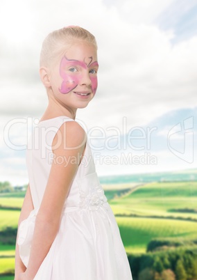 Girl in pink facepaint against fields with flare