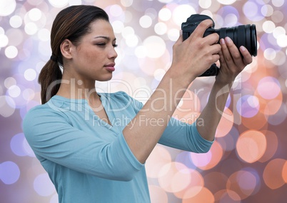 young photographer taking a photo. Blue, orange and white bokeh background