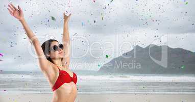 Woman in red bikini against blurry beach and confetti