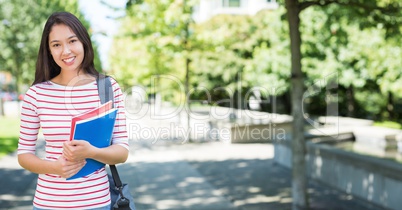 College student with books against blurry campus